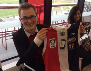 Kermie holding up a St Kilda VWFL football jumper.